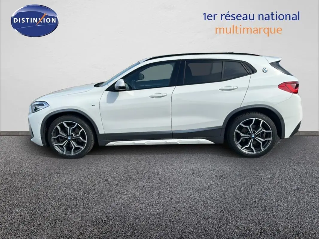 BMW X2 blanc en vue profil droit, soulignant ses jantes alliage 19 pouces et son design compact urbain.