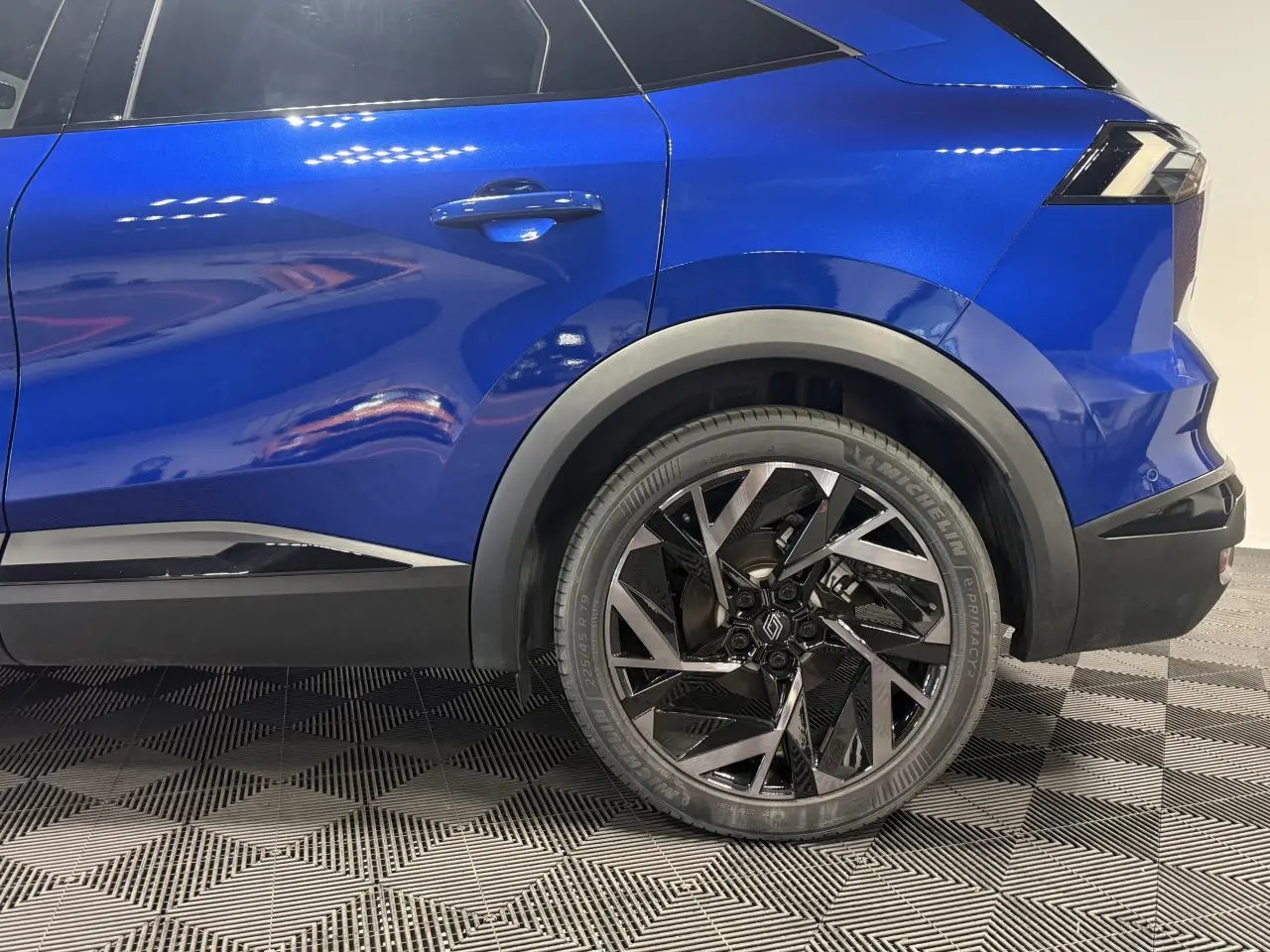 Vue latérale droite sur la partie arrière du Renault SYMBIOZ bleu avec jante aluminium 19 pouces au design géométrique.