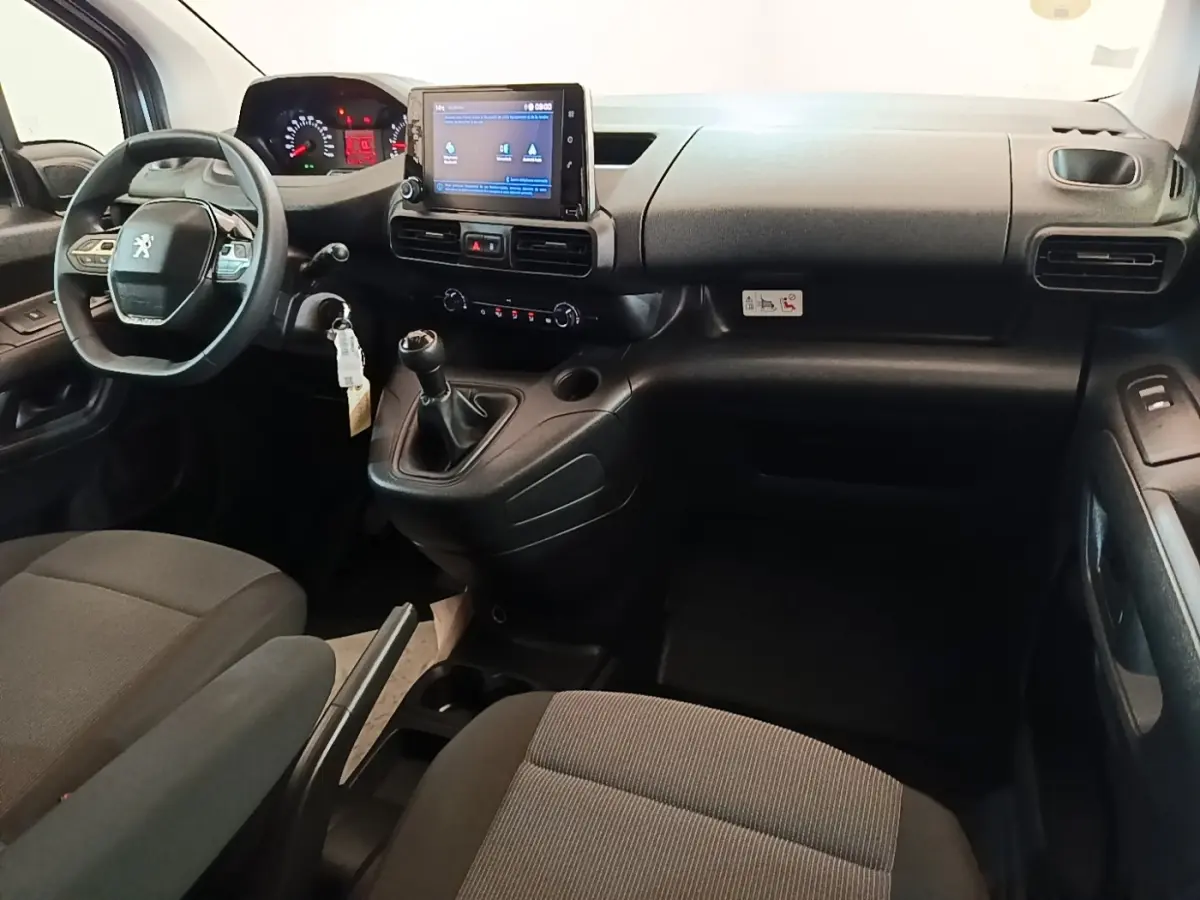 Vue intérieure du poste de conduite du Peugeot Partner blanc 2020, avec tableau de bord et écran tactile central.