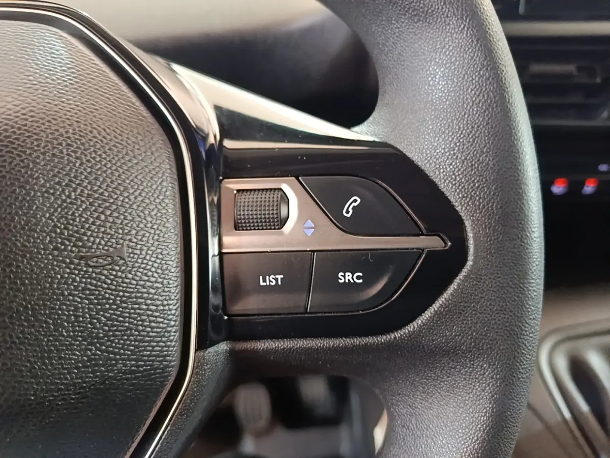 Gros plan sur les commandes au volant à droite du Peugeot Partner blanc, version BlueHDi 100 S&S Long Cabine App.