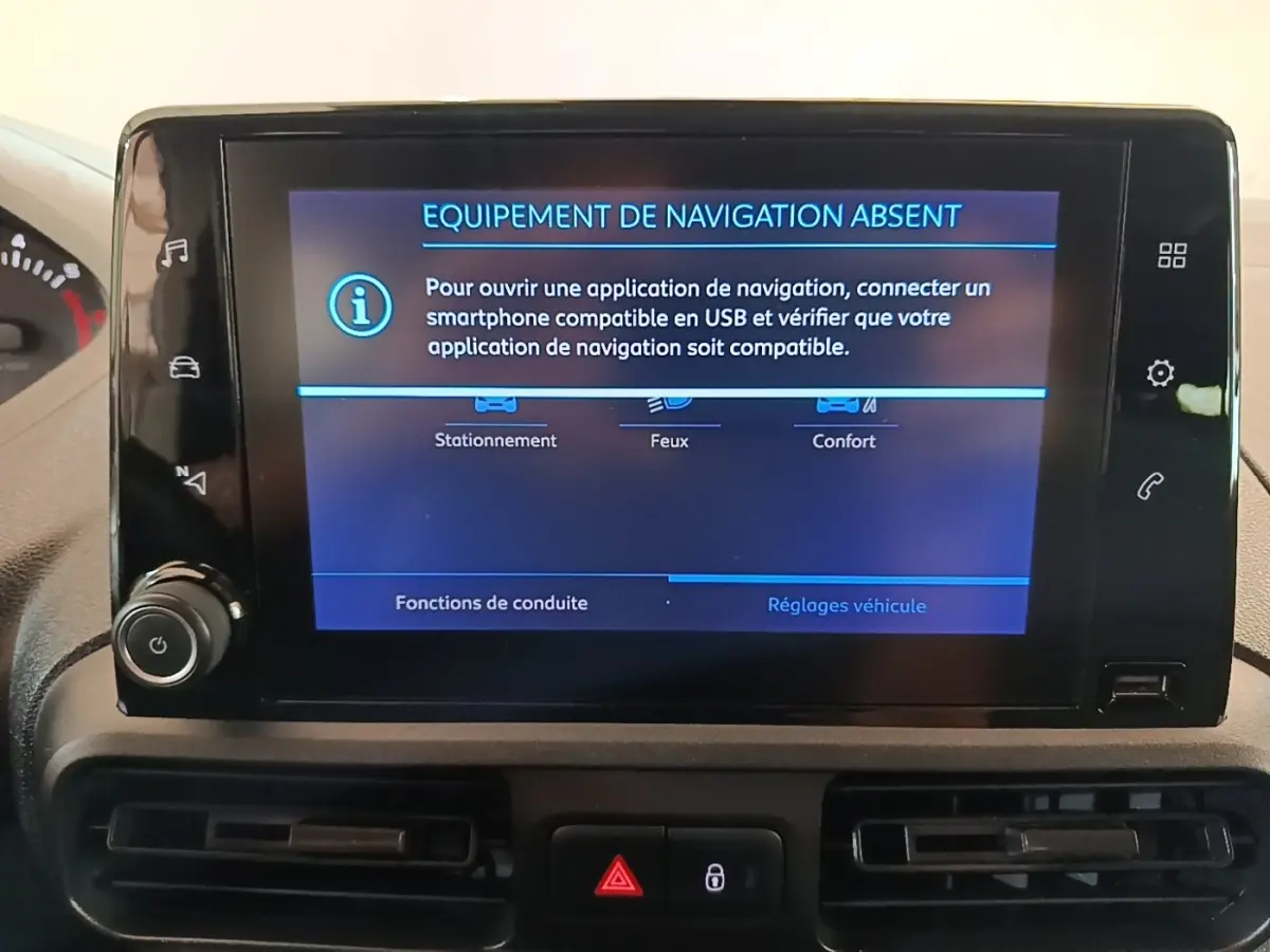 Écran central du tableau de bord du Peugeot Partner blanc, affichant un message d'absence d'équipement de navigation.