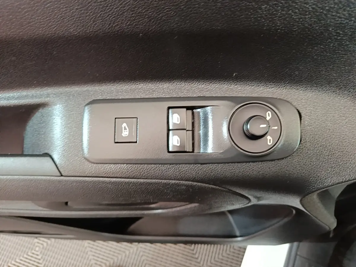 Gros plan sur les commandes de réglage des rétroviseurs et des vitres côté conducteur du Peugeot Partner blanc 2020.