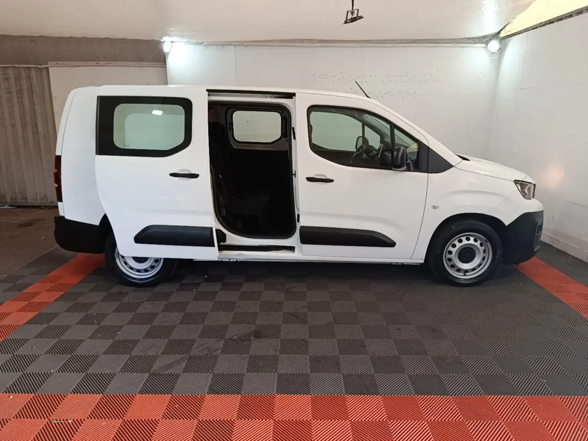 Vue latérale droite d’un Peugeot Partner blanc 2020 avec porte coulissante ouverte en intérieur.