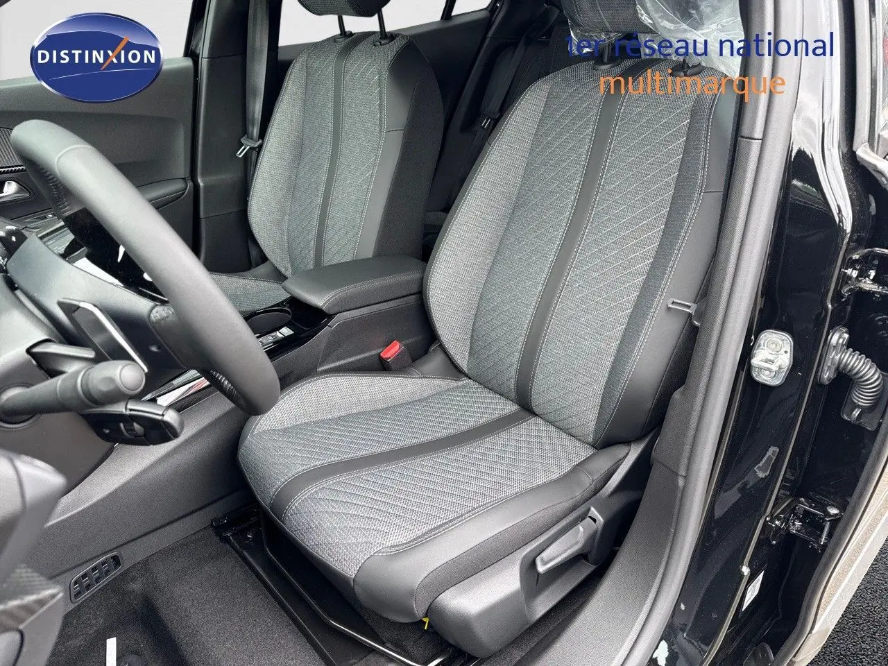 Vue intérieure côté conducteur du Peugeot 2008 Hybrid 136ch Allure 2025, sièges tissu gris et cuir noir, portière ouverte.