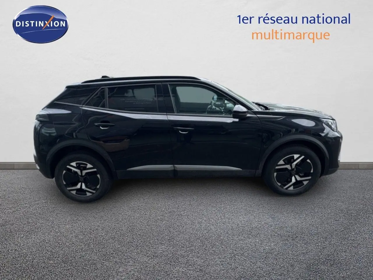 Profil côté droit d'un Peugeot 2008 HYBRID 136CH Allure noir métal avec jantes noires et toit panoramique.