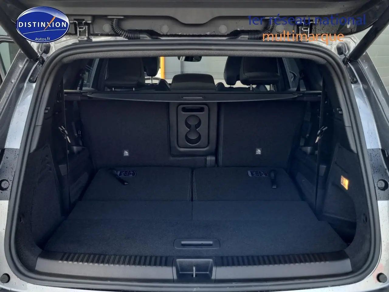 Coffre ouvert du Renault Espace VI gris schiste, montrant la banquette arrière rabattue et l'espace de chargement plat.