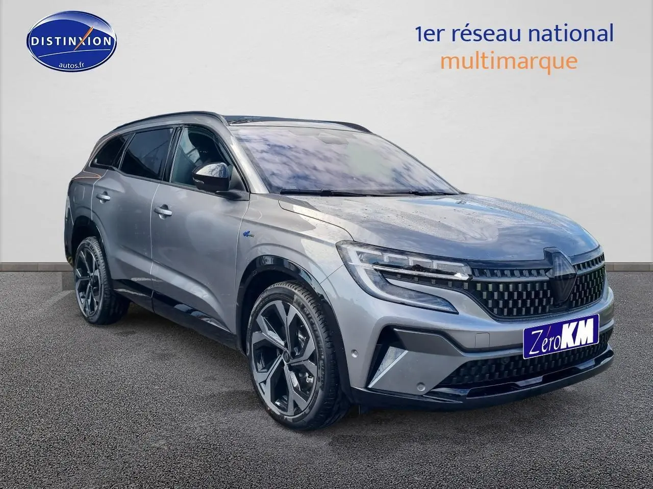 Renault Espace VI gris schiste en 3/4 avant droit, avec calandre à damiers et jantes alliage 20 pouces diamantées noir.