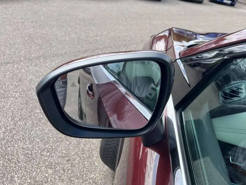 Rétroviseur côté gauche du Nissan Qashqai e-POWER 2023 Rouge Passion, avec reflet de la portière et jante alliage 19 pouces.