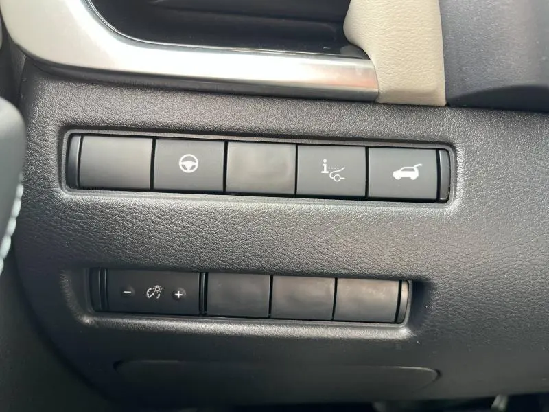 Détail des commandes de réglages et ouverture du coffre sur le tableau de bord noir du Nissan Qashqai e-POWER Rouge Passion.