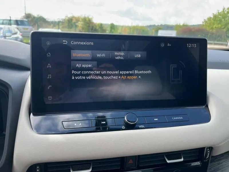 Écran tactile central du tableau de bord du Nissan Qashqai e-POWER 2023 avec interface Bluetooth et Wi-Fi visible.