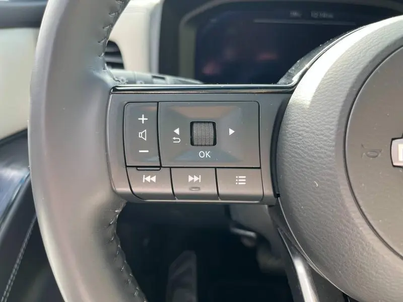 Gros plan sur les commandes multifonctions au volant cuir noir du Nissan Qashqai e-POWER 2023.