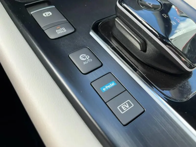 Gros plan sur la console centrale noire du Nissan Qashqai e-POWER avec commandes e-Pedal, EV et frein de parking auto.
