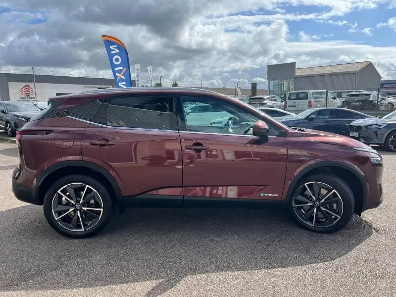 Profil côté gauche du Nissan Qashqai e-POWER 2023 Rouge Passion avec jantes alliage 19 pouces et vitres teintées.