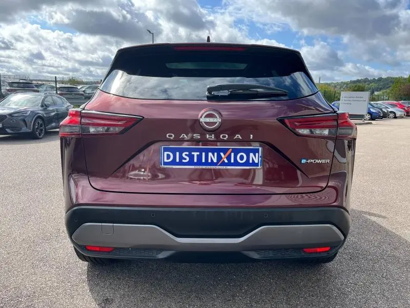 Vue arrière d'un Nissan Qashqai e-POWER 2023 en Rouge Passion avec logo et feux LED distinctifs visibles.