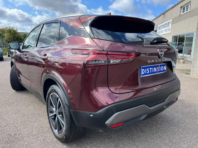 Vue 3/4 arrière droite du Nissan Qashqai e-POWER 2023 en Rouge Passion avec jantes alliage 19 pouces et vitres teintées.