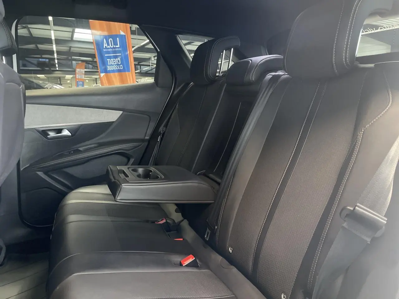 Vue latérale droite de la banquette arrière noire avec accoudoir central relevé du Peugeot 3008 GT 2022.