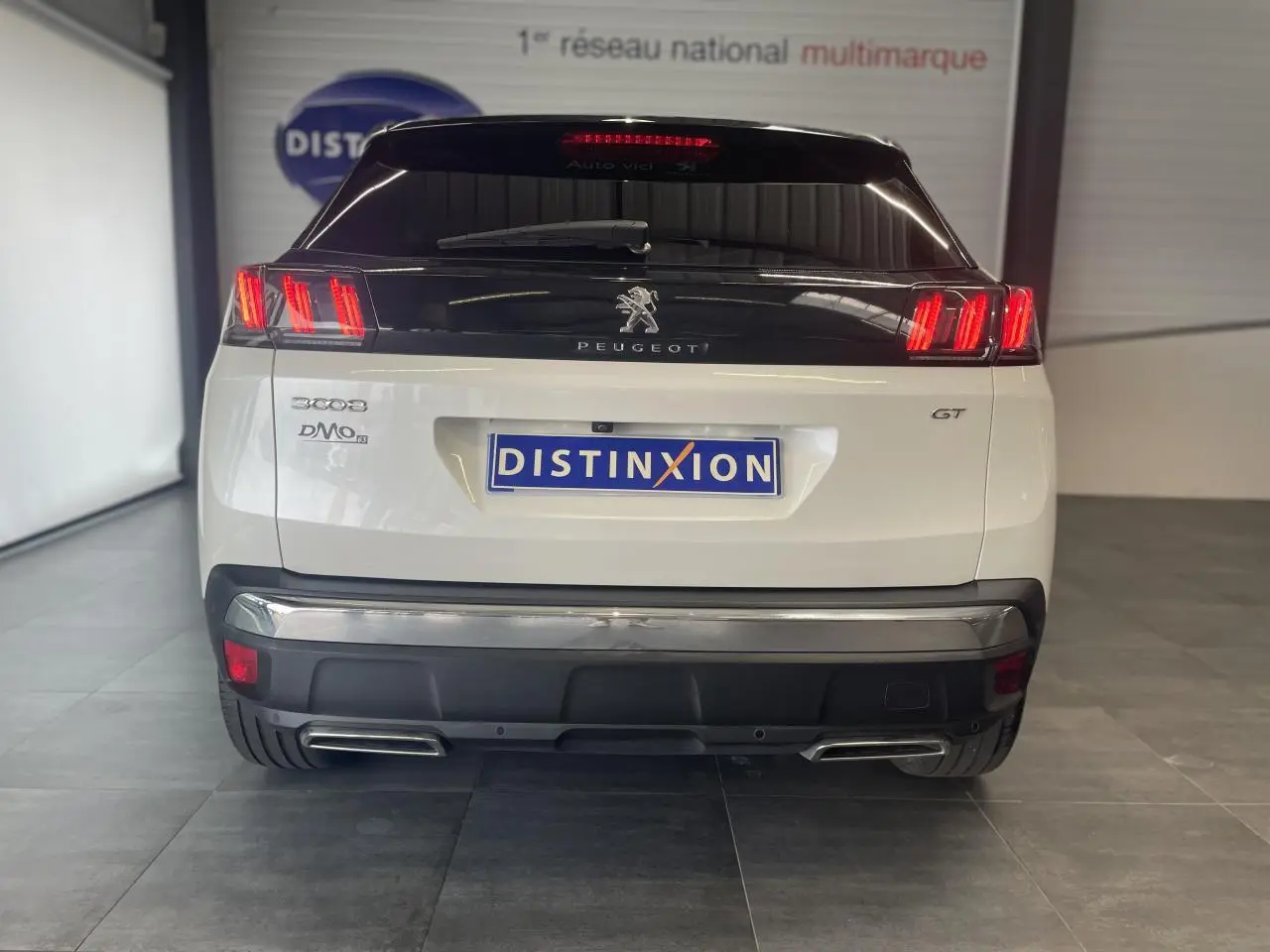 Vue arrière d’un Peugeot 3008 GT blanc nacré avec feux LED et double sortie d’échappement chromée.