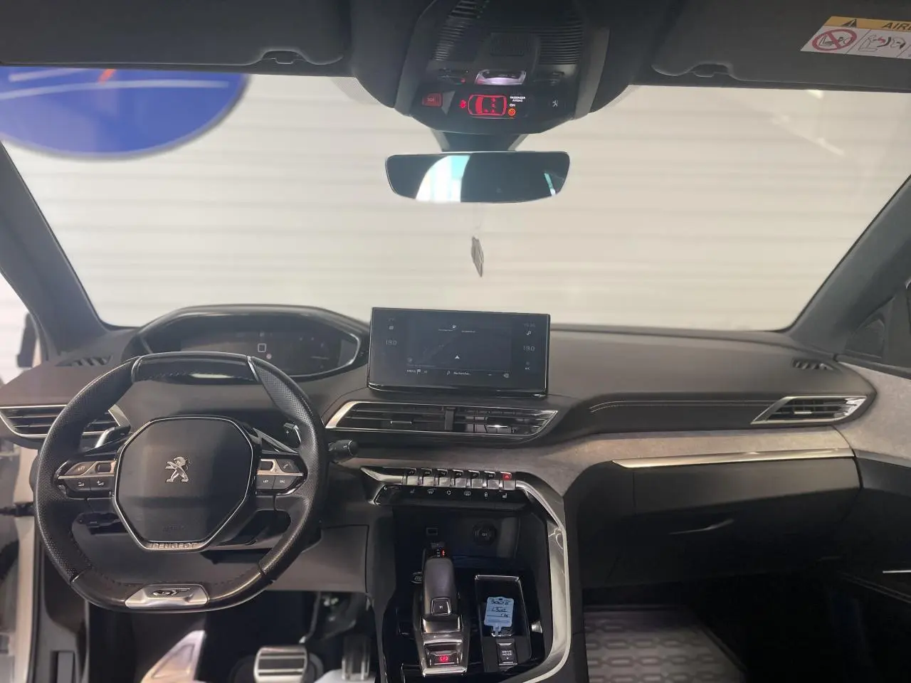 Vue intérieure avant du Peugeot 3008 GT 2022, tableau de bord et volant compact noir avec inserts chromés.