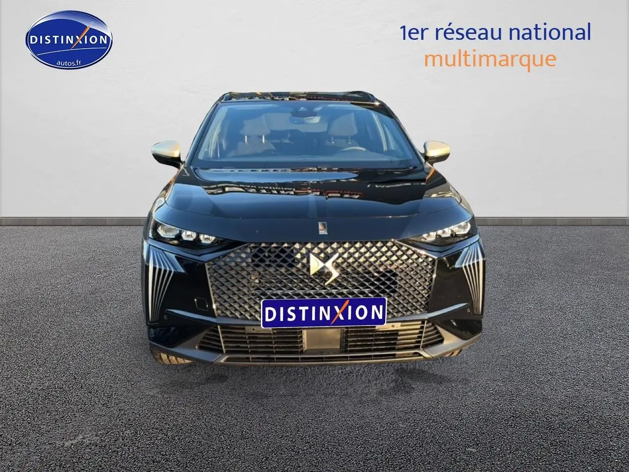 Vue de face du DS7 noir avec sa calandre distinctive et ses phares LED fins et anguleux.