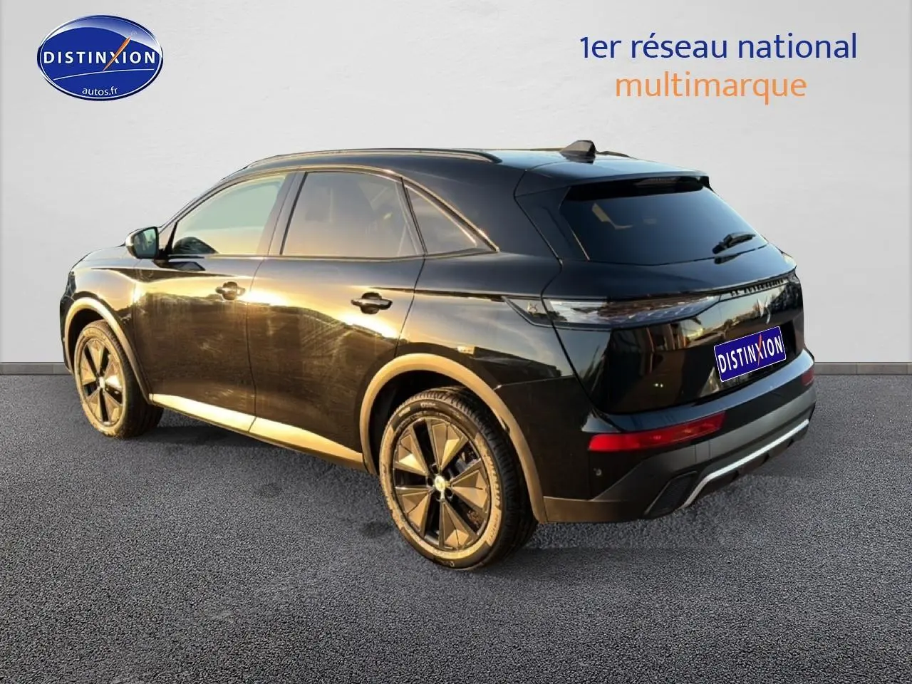 DS7 noir vue 3/4 arrière droit, jantes alu distinctives et vitres arrière surteintées au soleil couchant.