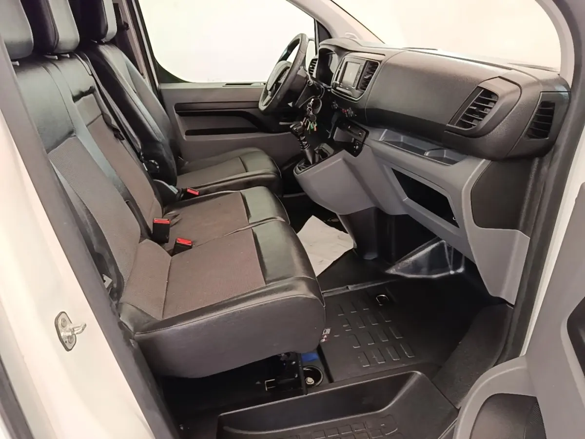 Vue intérieure côté conducteur du Peugeot Expert Fourgon blanc, montrant les sièges avant et le tableau de bord.