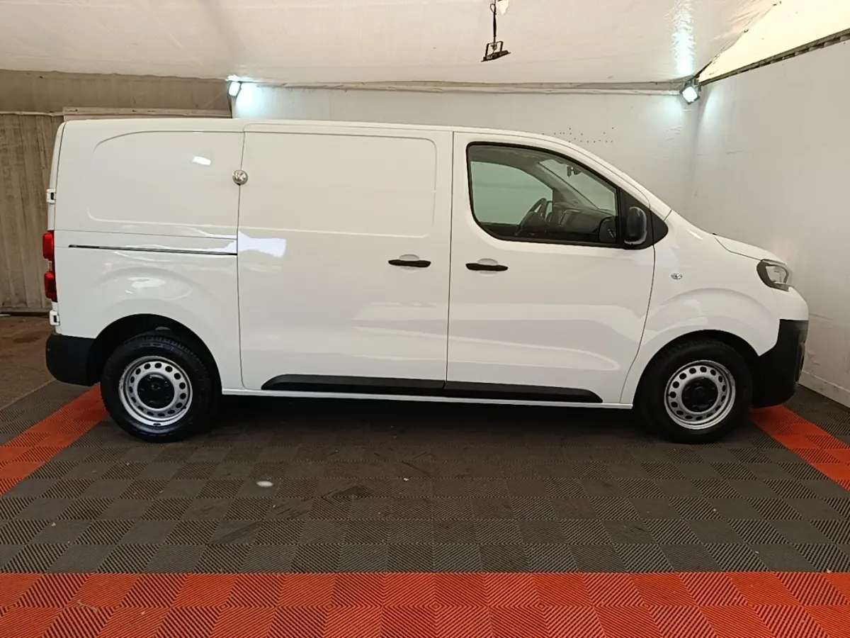 Vue de profil côté gauche d’un Peugeot Expert Fourgon blanc, avec portes latérales pleines et jantes acier noires.