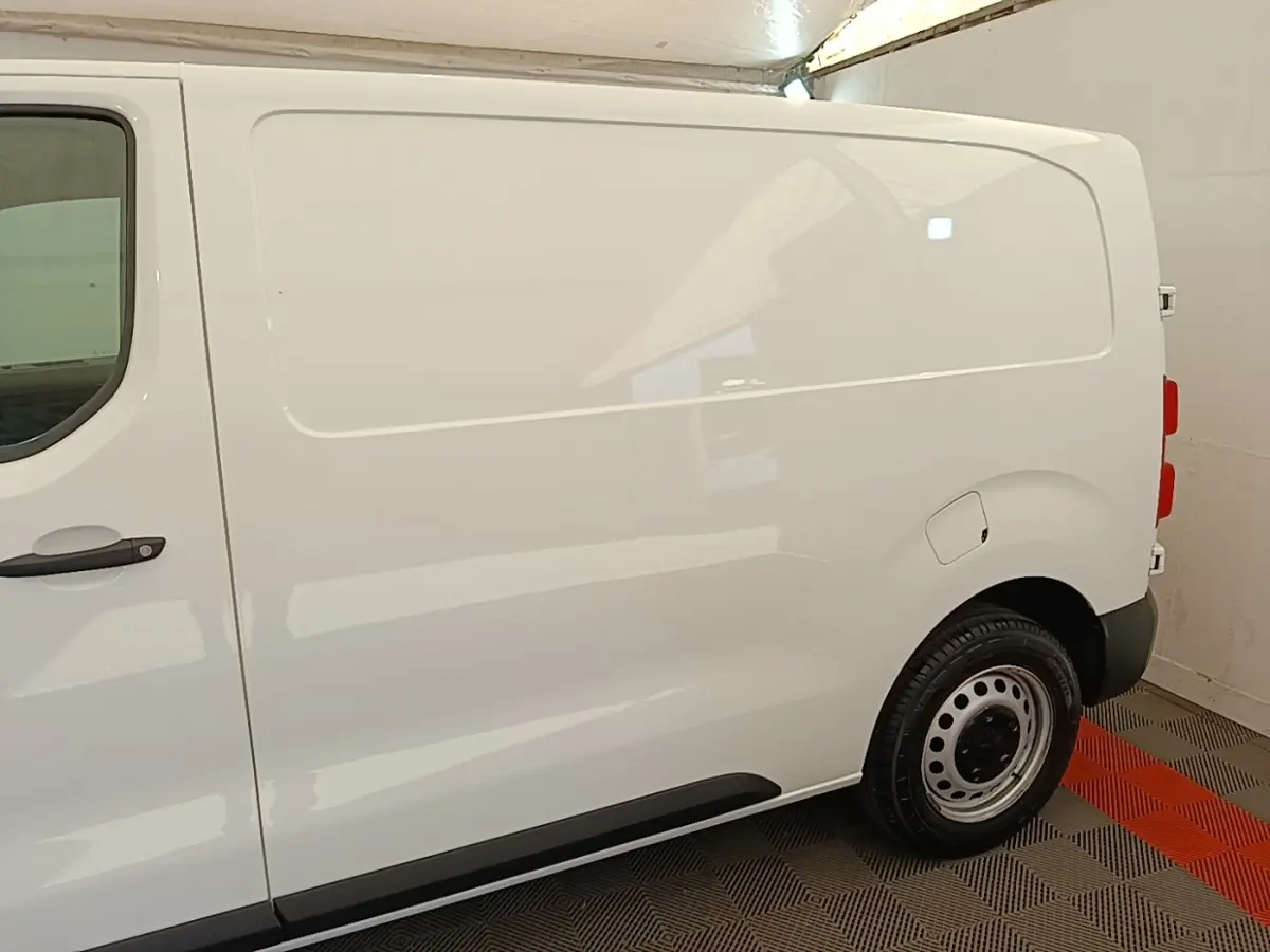 Vue latérale droite d'un Peugeot Expert Fourgon blanc, avec porte latérale pleine et jante acier noire.
