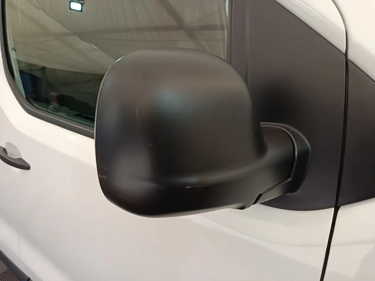 Gros plan sur le rétroviseur noir côté droit du Peugeot Expert Fourgon blanc, vue latérale partielle.