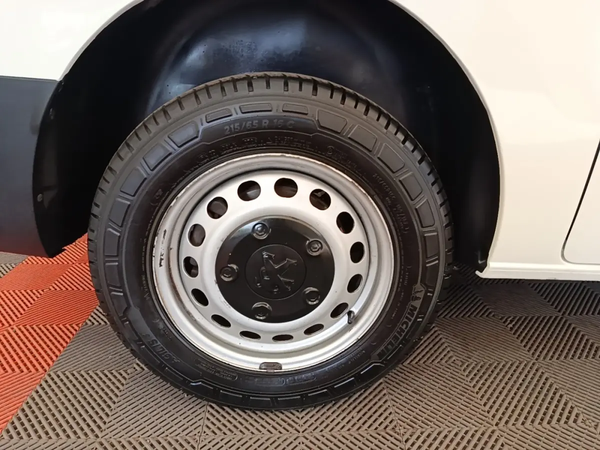 Gros plan sur la roue avant droite en jante acier du Peugeot Expert Fourgon blanc, avec pneu Michelin visible.