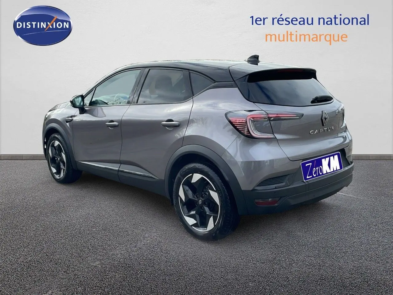 Vue 3/4 arrière droite du Renault Captur E-Tech hybride gris Cassiopée avec toit noir et jantes bicolores.