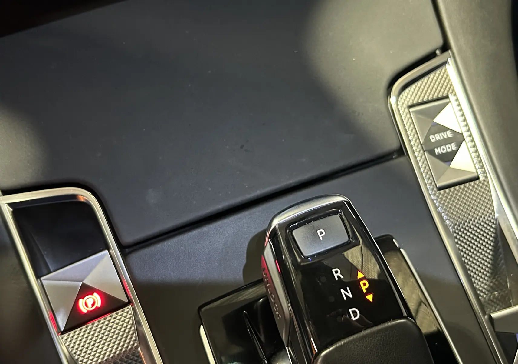 Le levier de vitesses automatique et les commandes Drive Mode et frein à main du DS7 BlueHDI 130 2024 en intérieur noir.