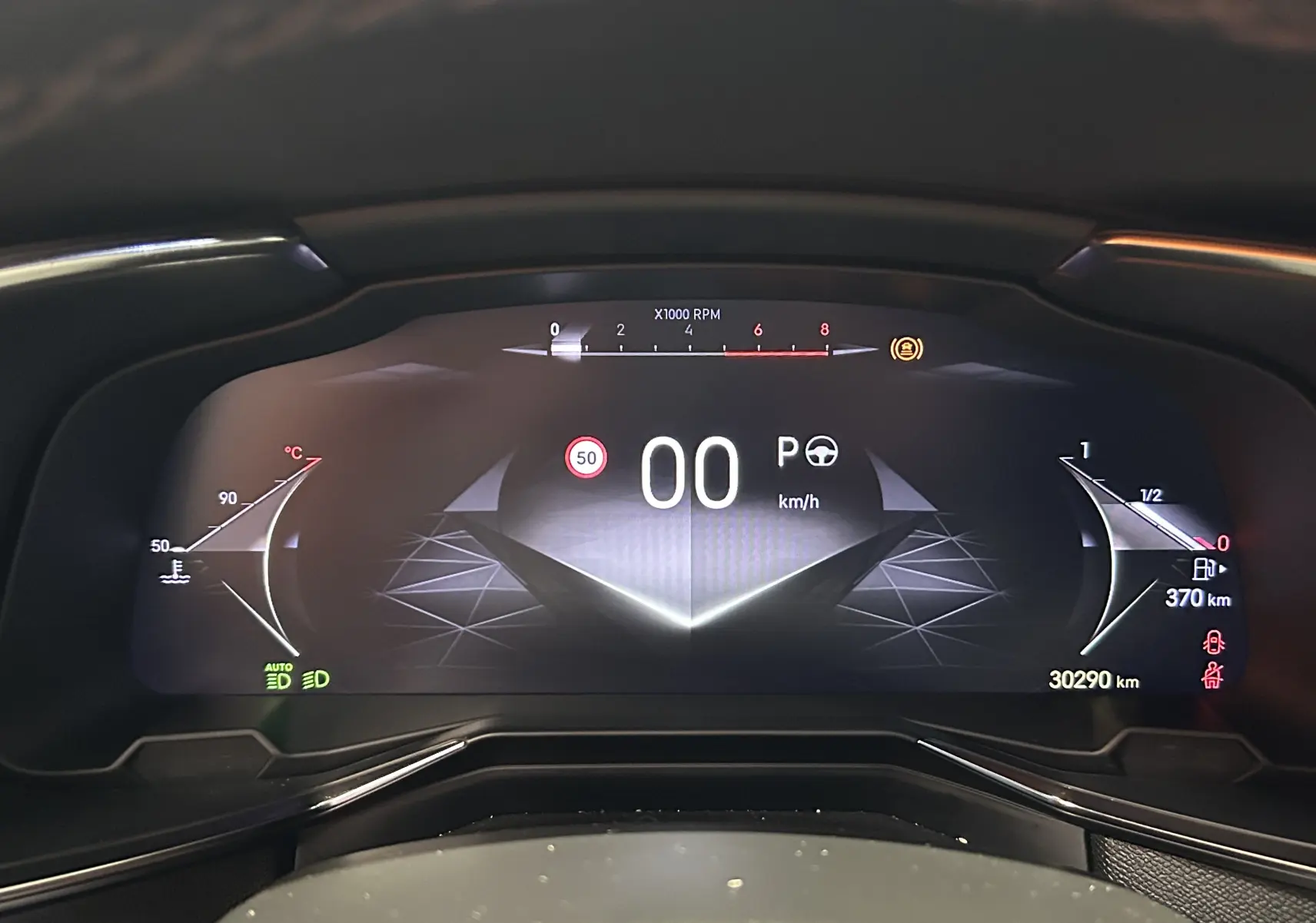 Tableau de bord numérique du DS7 2024 affichant la vitesse à 0 km/h et l'autonomie de 370 km, vue de face.