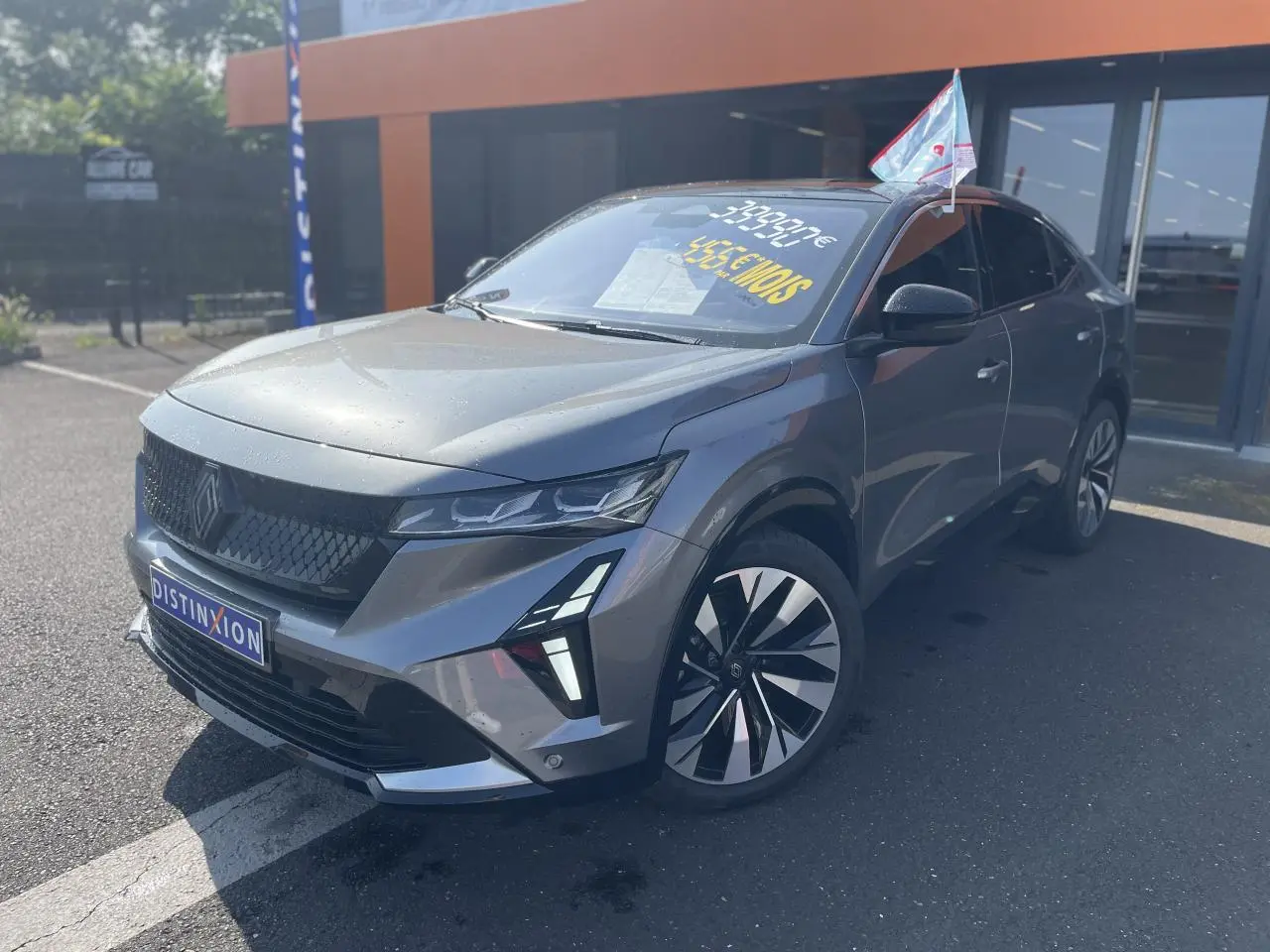 Vue 3/4 avant droit du Renault Rafale gris avec toit noir, jantes diamantées et calandre noire distinctive.