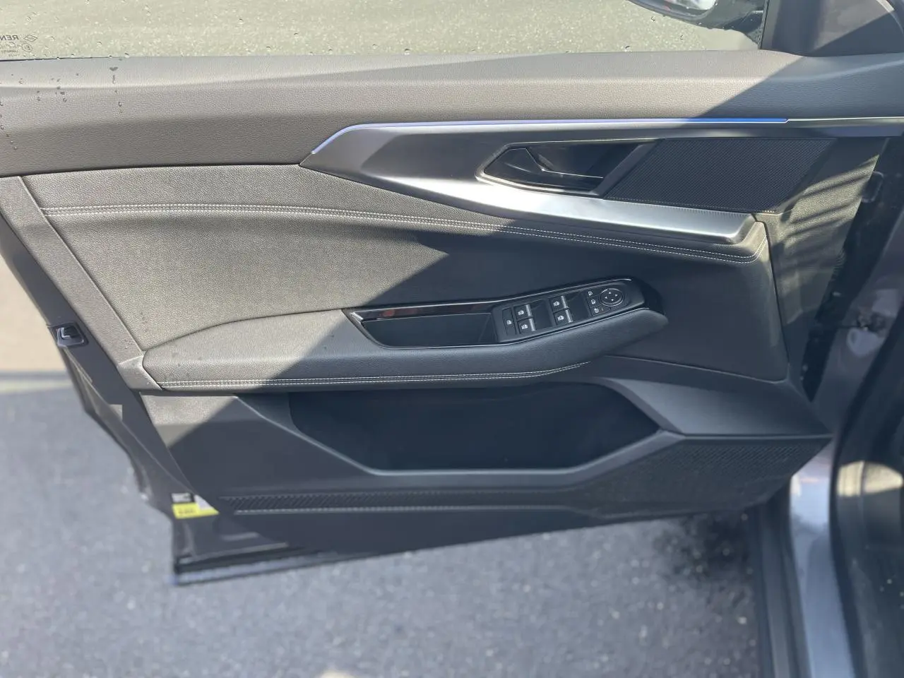 Vue côté gauche de la porte avant gris foncé du Renault Rafale 2025 avec commandes électriques et surpiqûres argentées.