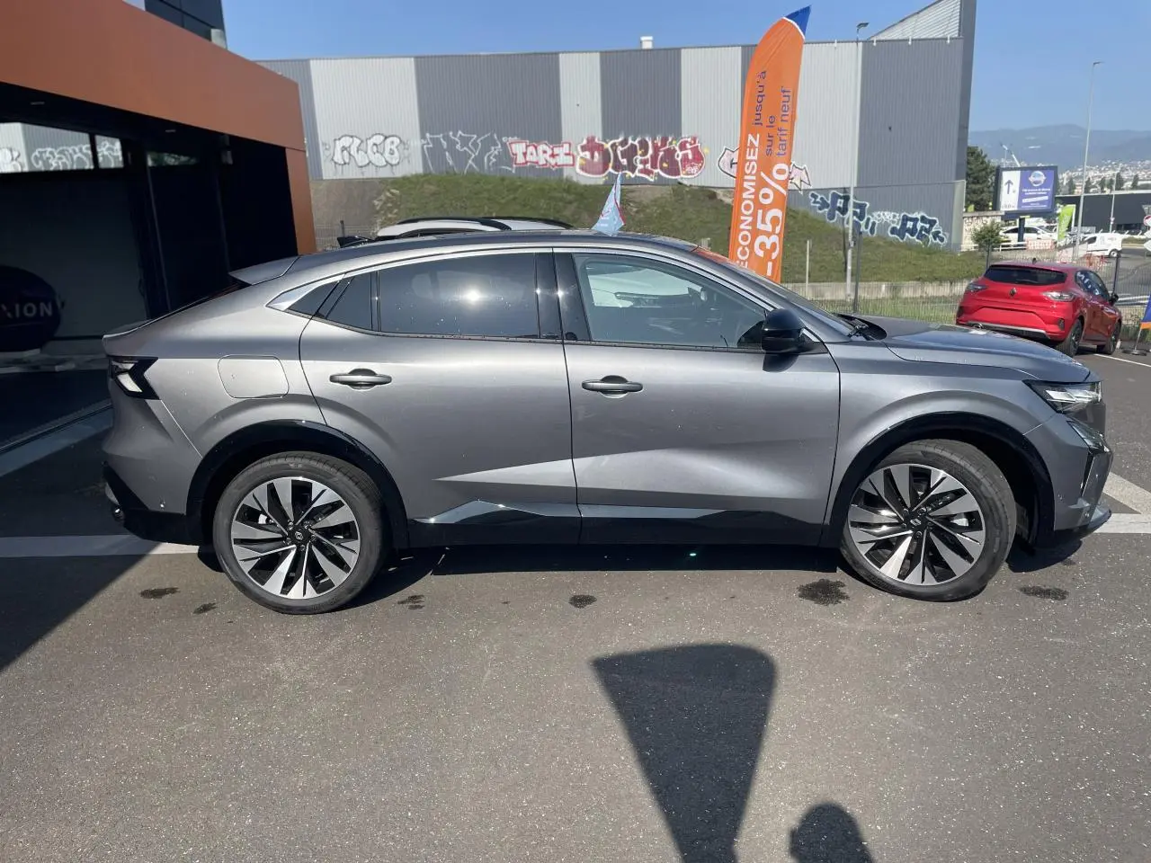 Vue de profil côté gauche d’un Renault Rafale gris avec toit noir, jantes alliage et lignes sculptées modernes.