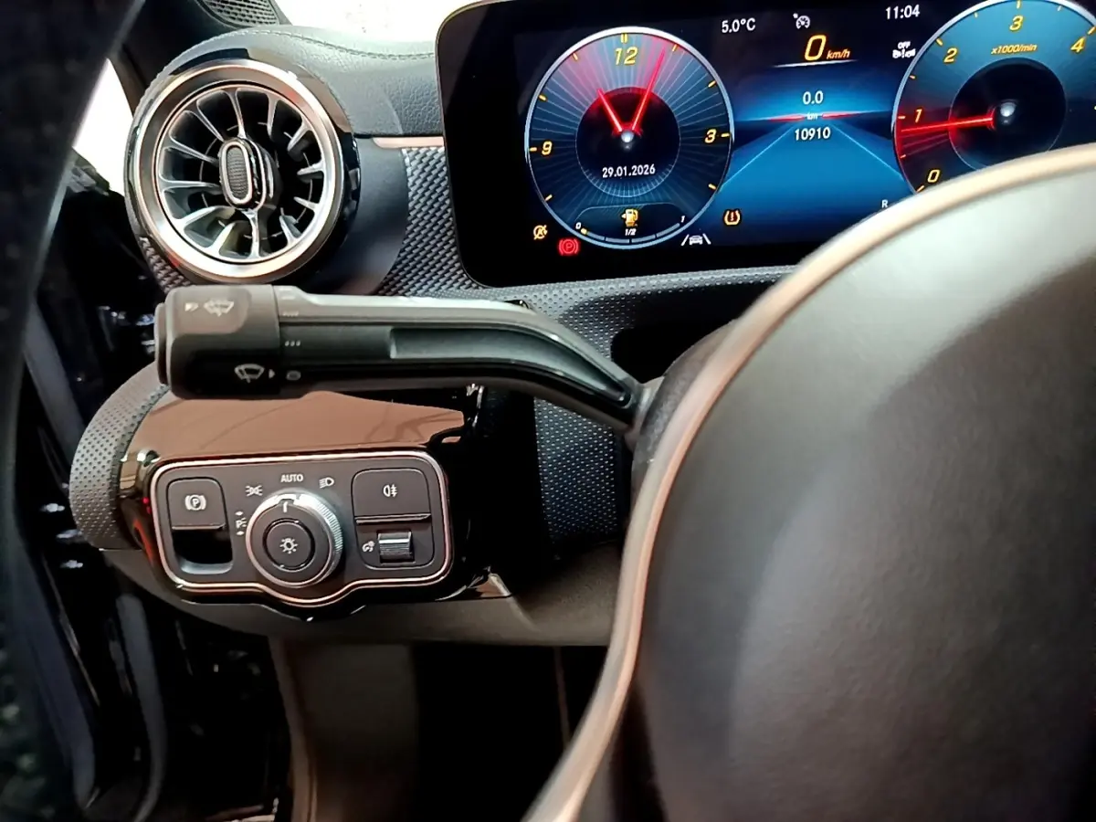 Vue intérieure côté gauche du tableau de bord de la Mercedes Classe A 200 d, avec commandes d’éclairage et écran digital lumineux.