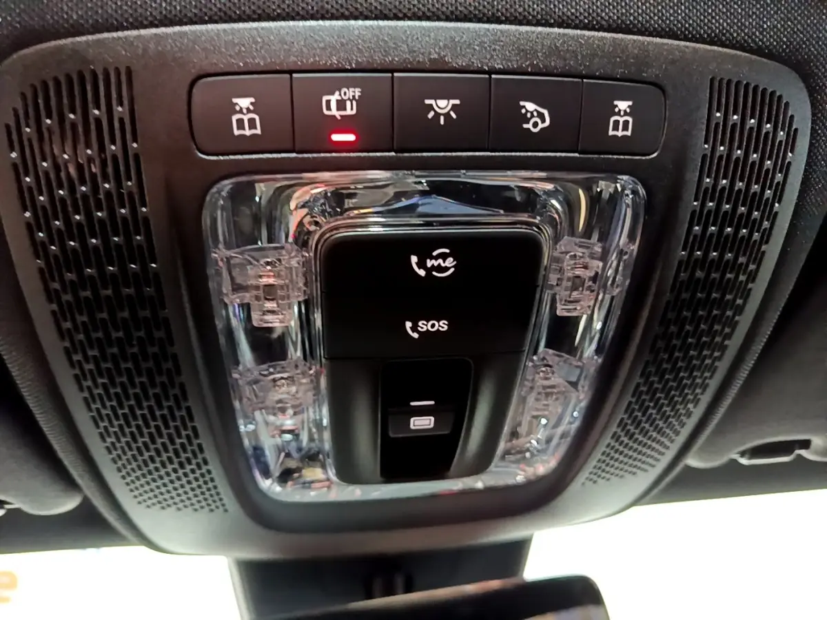 Gros plan sur la console de plafonnier noire avec boutons SOS, appel d'urgence et éclairage intérieur d'une Mercedes Classe A 200 d.