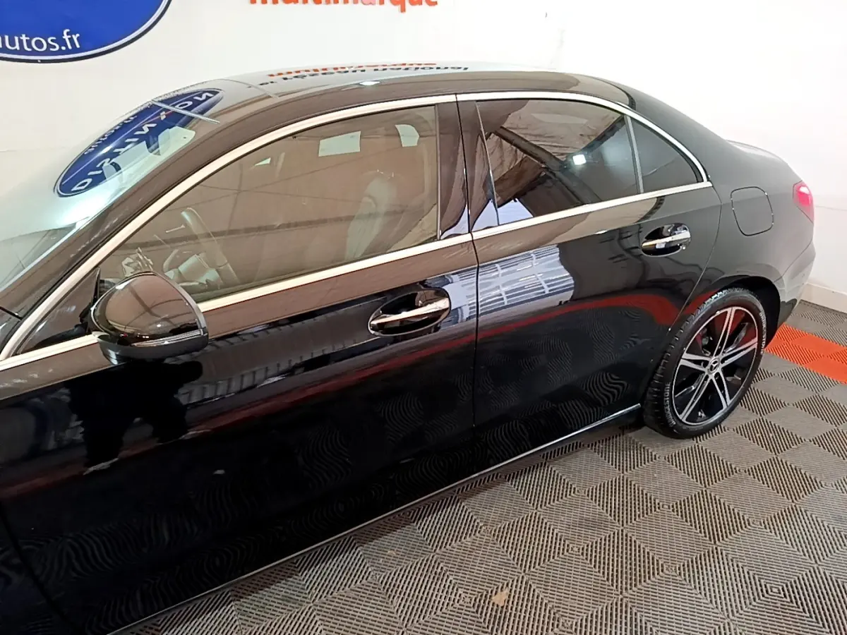 Vue latérale droite d'une Mercedes Classe A berline noire avec jantes alliage et poignées chromées.