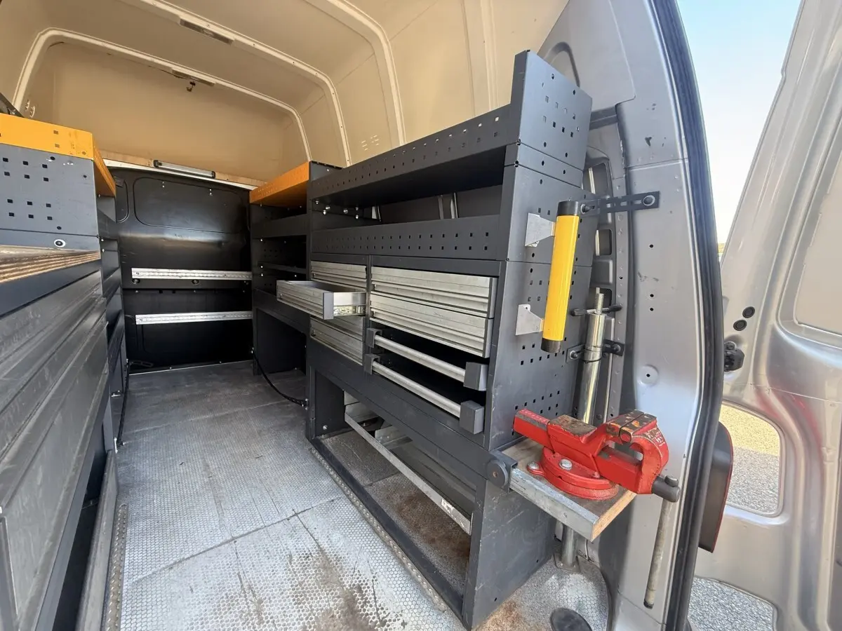 Vue intérieure arrière droite du Volkswagen Transporter gris clair 2022 avec aménagements de rangement et étagères métalliques.