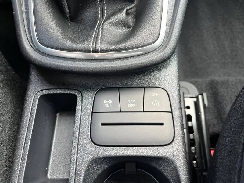 Gros plan sur la console centrale noire du Ford Puma 2023 montrant les boutons de contrôle TCS, arrêt auto et aide au démarrage en côte.