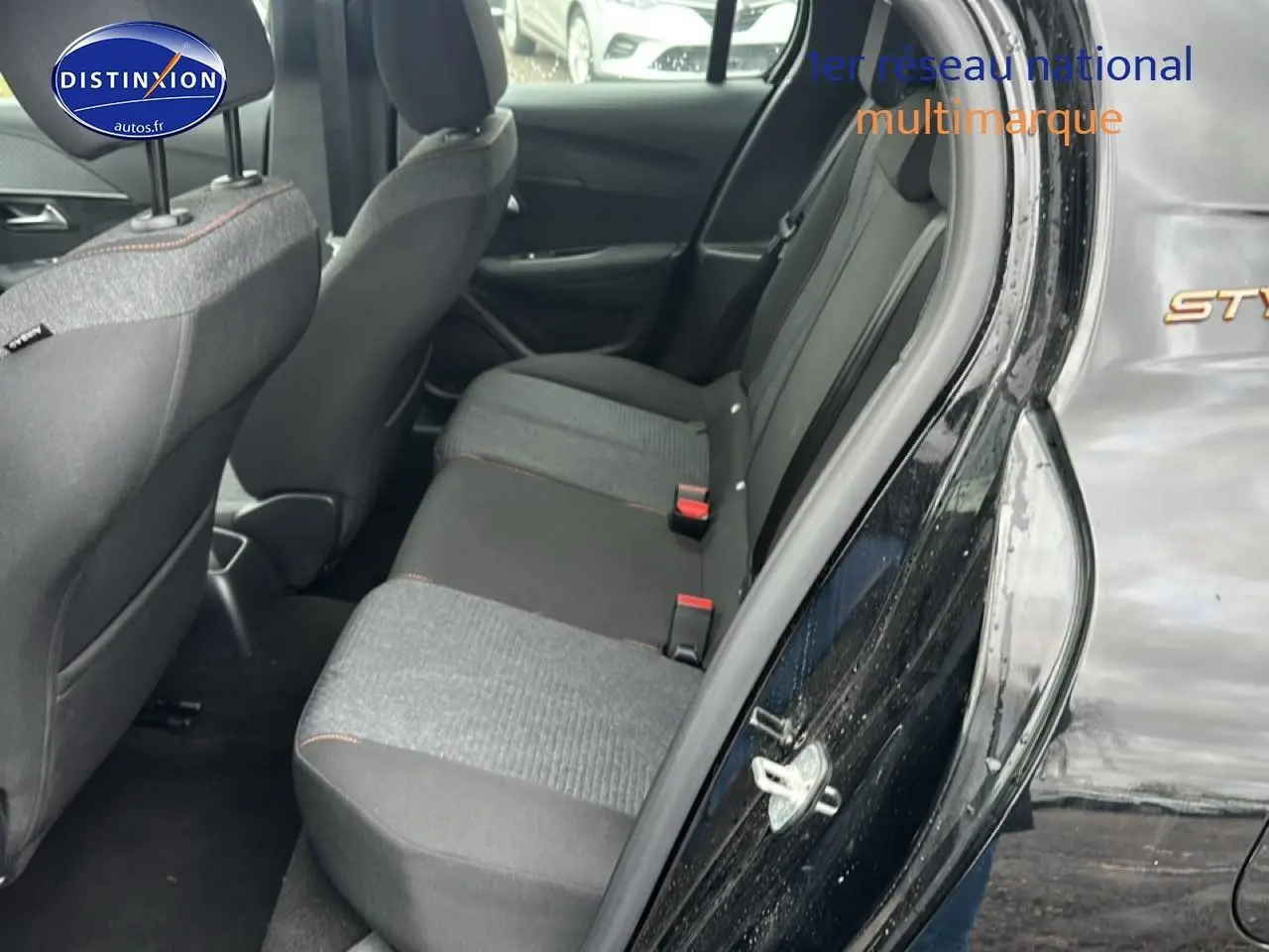 Vue côté droit sur la banquette arrière grise et noire d'une Peugeot 208 1.2 100 Style noire avec porte ouverte.