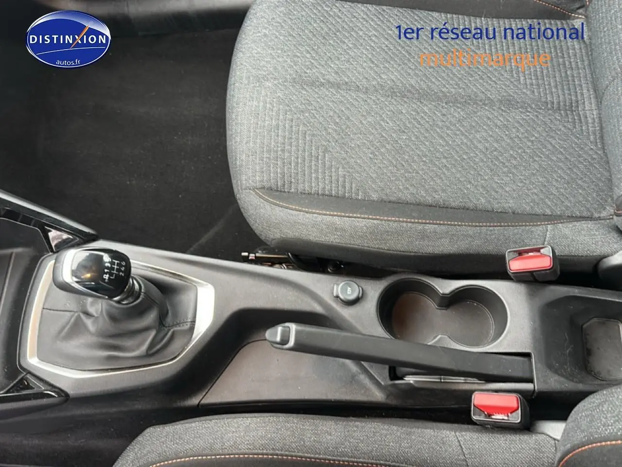 Vue rapprochée de la console centrale de la Peugeot 208 noire, montrant levier de vitesse manuel et frein à main.