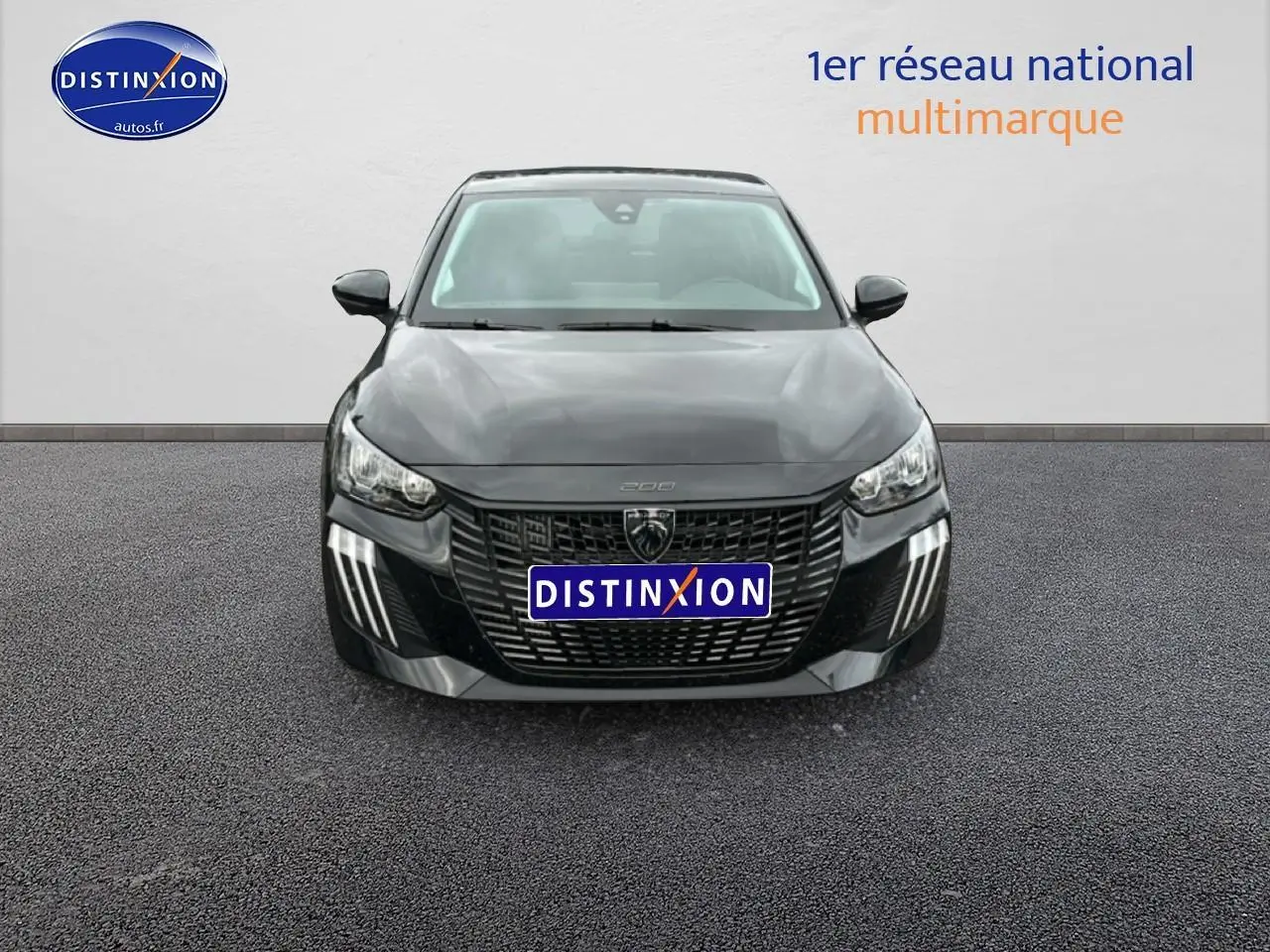 Vue avant d'une Peugeot 208 noire 2025 avec calandre imposante et feux diurnes à LED en griffes.