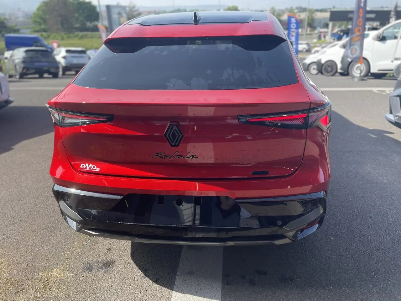 Vue arrière d'une Renault Rafale rouge avec toit noir, feux LED fins et logo noir au centre du hayon.