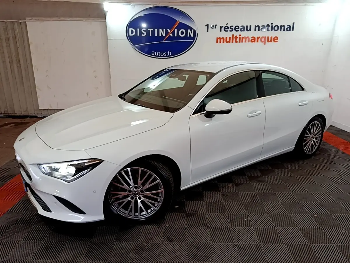 Mercedes Classe CLA 200 d Business Line blanc vue 3/4 avant droit, phares allumés et jantes alliage multibranches.