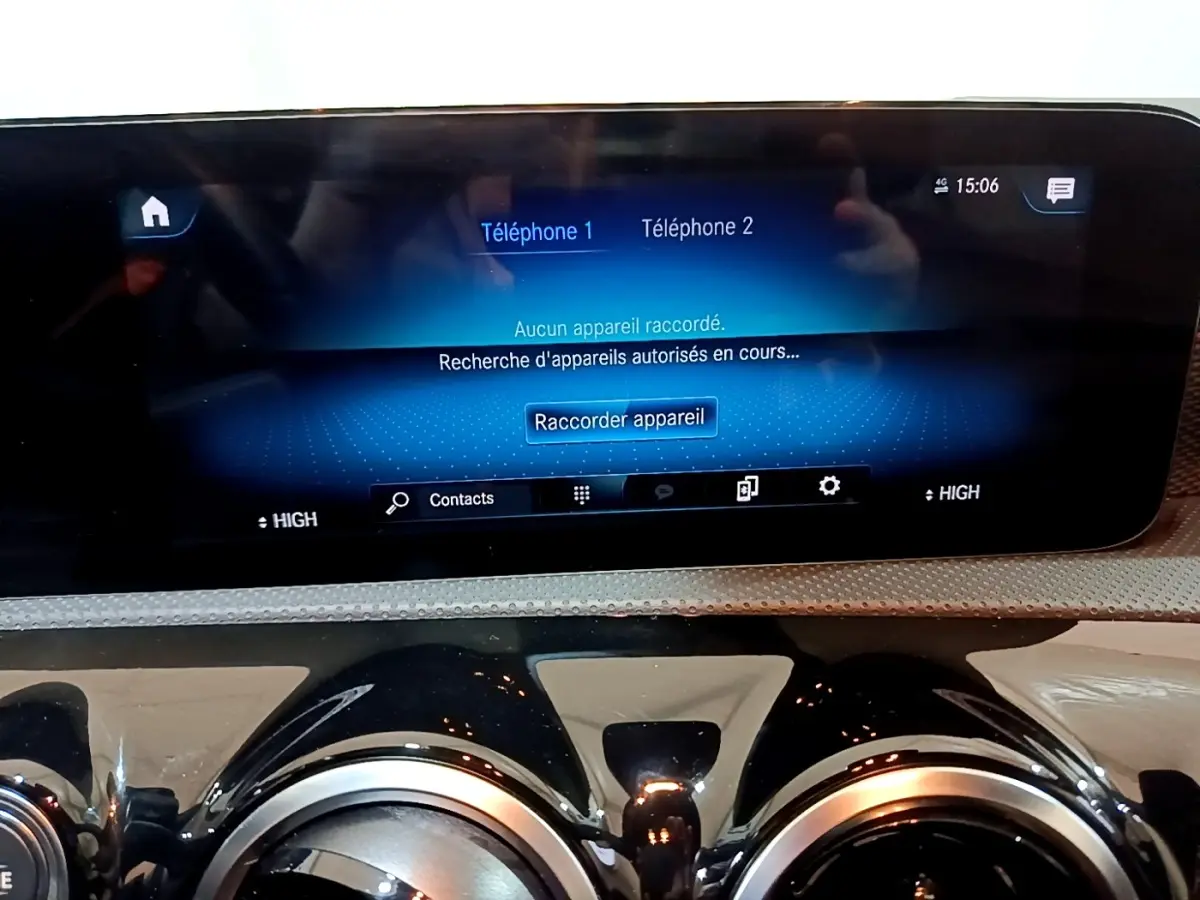 Vue rapprochée de l’écran tactile central bleu et des aérateurs ronds noirs du tableau de bord de la Mercedes CLA 200 d Business Line blanche.