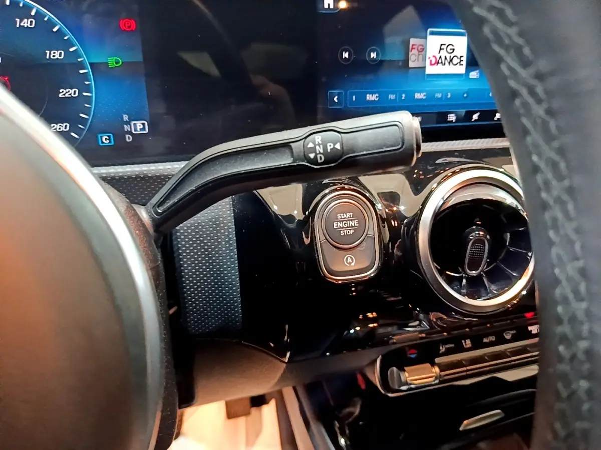 Gros plan intérieur sur le tableau de bord noir brillant de la Mercedes CLA 200 d, avec levier de vitesses et bouton démarrage.