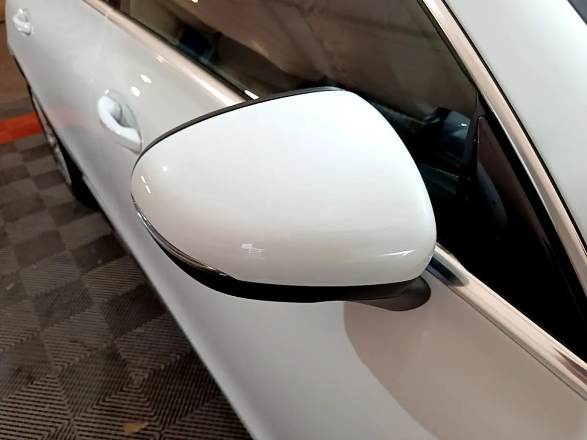 Gros plan sur le rétroviseur droit blanc d’une Mercedes CLA 200 d Business Line 2021, avec porte et vitre partiellement visibles.