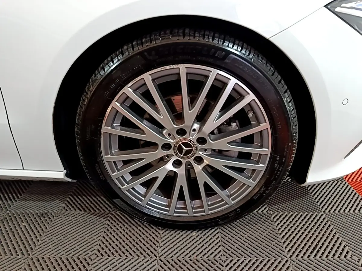 Gros plan sur la roue avant droite argentée d’une Mercedes CLA 200 d Business Line blanche, avec jante multi-branches.