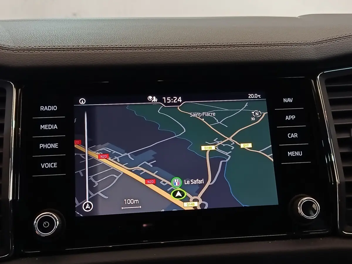 Écran tactile central du Skoda Kodiaq blanc 2022 affichant la navigation avec carte et commandes latérales.